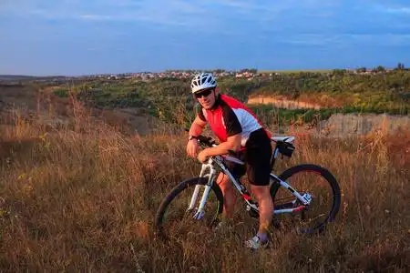 年轻成人自行车骑山地自行车在农村照片