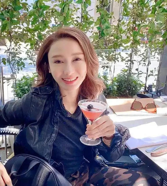 黎姿近照曝光,穿军绿色大衣烫大波浪,双手盘着模样像路人