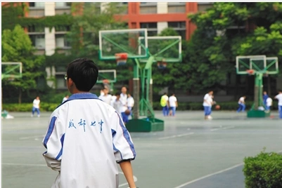 一初中生身着校服在操场上活动,校服背面成都七中字样是成都七中校服