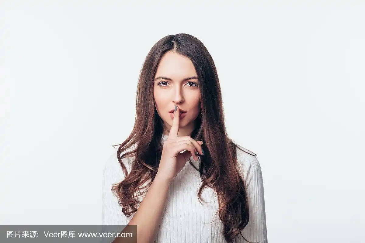 年轻女子做安静的手势孤立在白色的背景