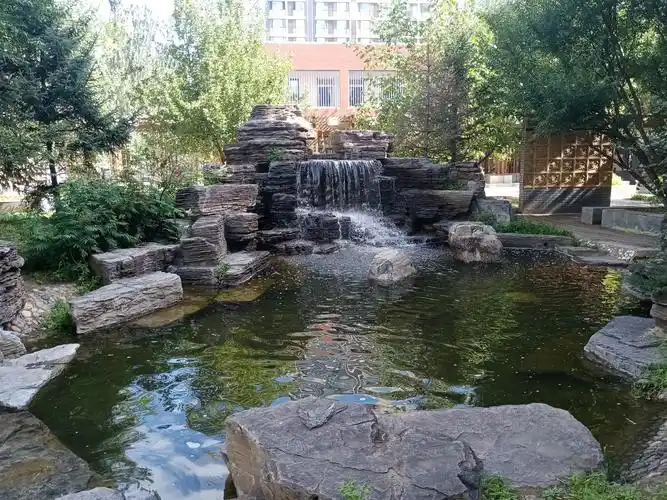 假山瀑布,流水致小池塘,又流过小桥,很有诗意