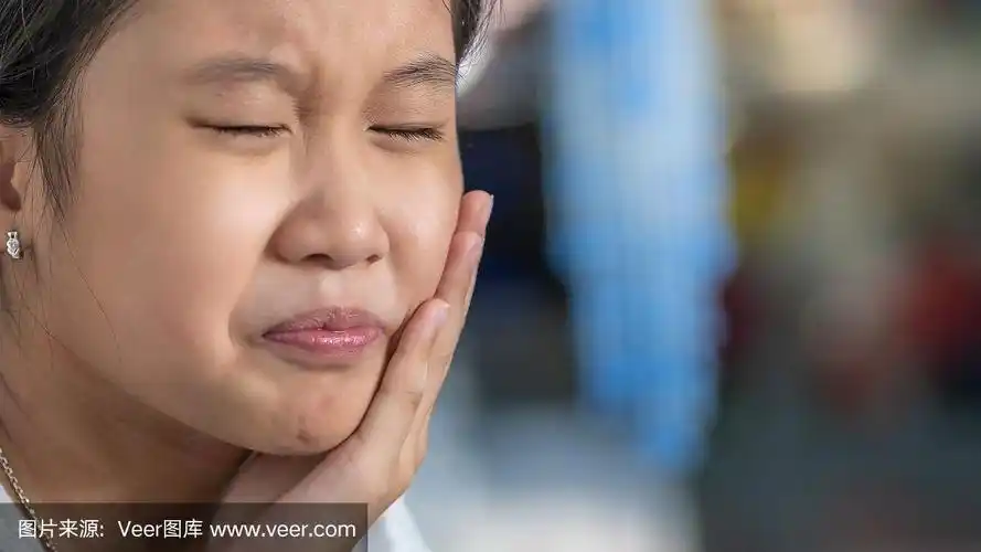 年轻的亚洲女孩有一个牙痛在痛苦的表情