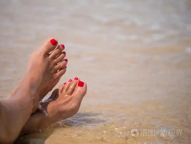 假期的概念.在海滩上放松的女人脚特写
