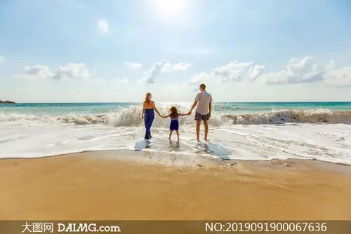 沙滩上散步的一家三口背影摄影图片