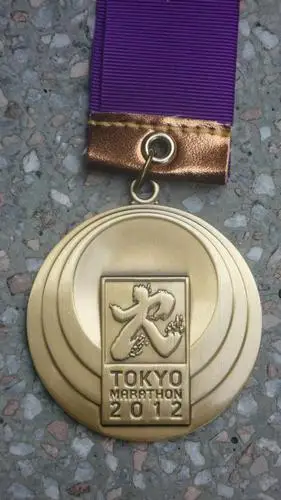 东京马拉松的奖牌及记念tee设计年年不同,不知今年的奖牌是甚麼模样?