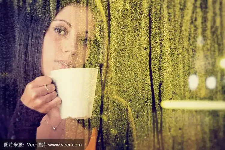 浪漫的年轻女孩望着窗外的雨