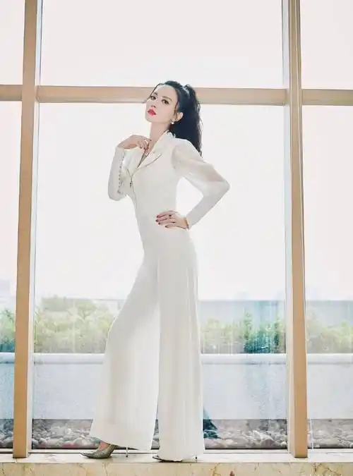 身高169cm个子高挑的张萌,选择了一件白色的v领连体裤,整体形象利落