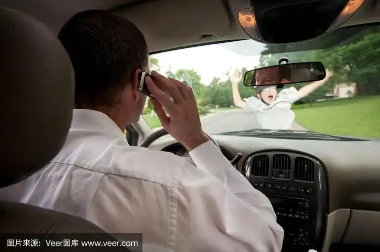 一个男人一边开车一边打电话,看不到一个男孩在玩滑板