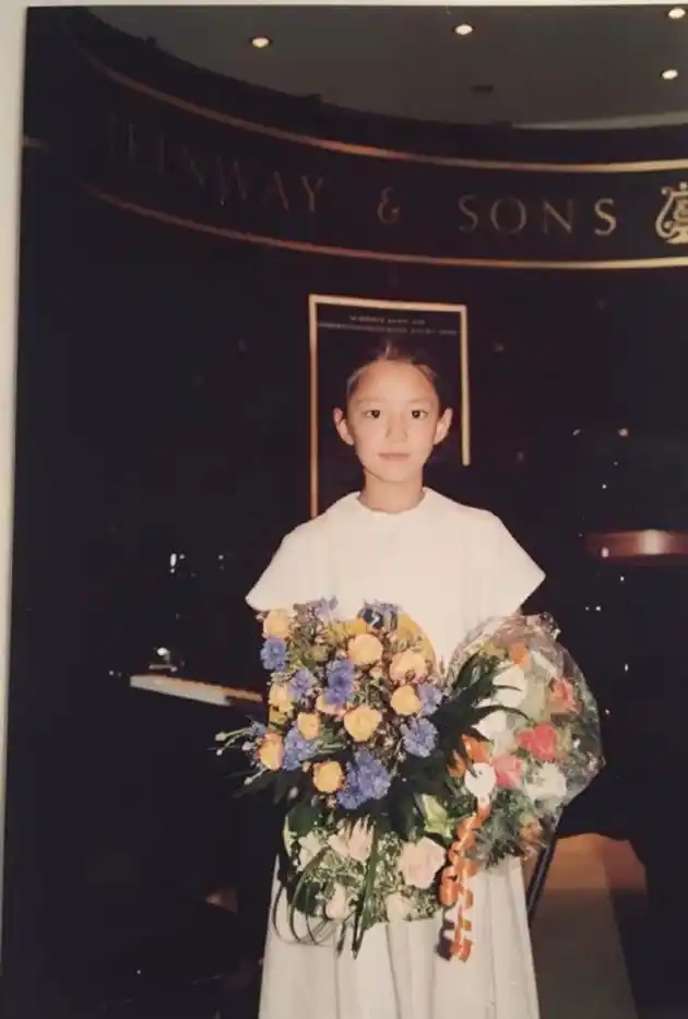 郎朗妻子吉娜分享童年演出照 穿白连衣裙捧花束清纯可爱