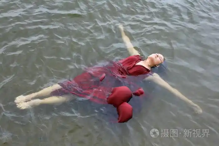 年轻美女穿红裙子躺在室外水淹死照片-正版商用图片0snaea-摄图新视界