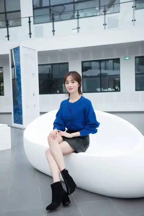 胡冰卿身穿印花外衣,下身搭配玄色小短裙,脚上搭配了一双玄色的高跟鞋