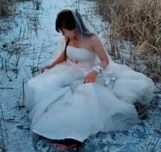 女孩为了拍不一样的婚纱照,光腿坐在雪地里,冻得她直跺脚!