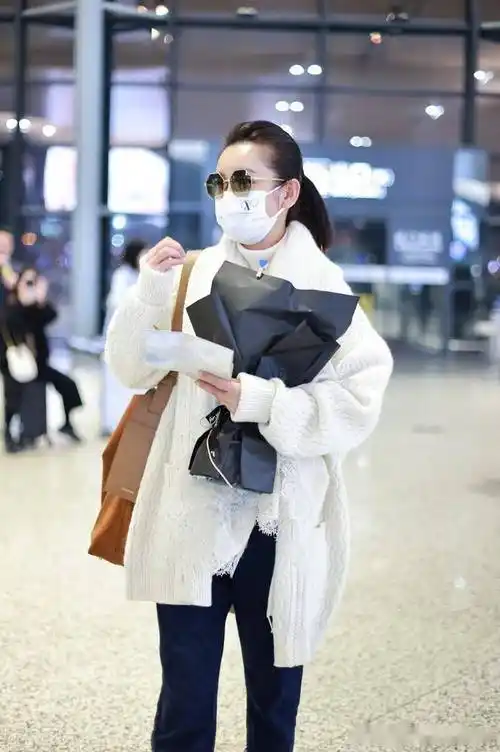 街拍:秦海璐白色毛衣开衫 牛仔裤 麂皮单肩包 墨镜温暖时髦_上海_机场