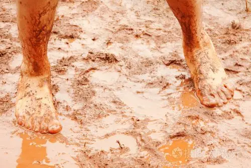 男人的赤脚脚在泥泞的水坑里照片-正版商用图片069sbm-摄图新视界