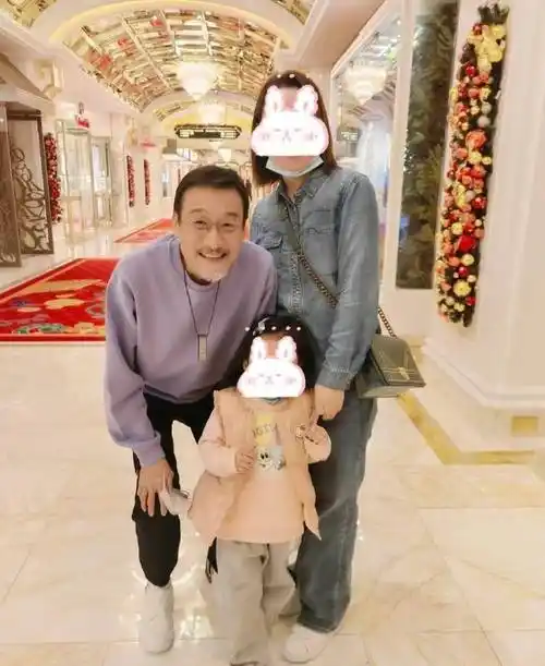 值得一提的是,梁家辉拍照时还特意屈膝照顾小女孩的身高,显得格外贴心