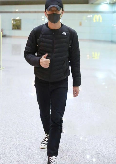 邓超身穿黑色羽绒服休闲裤,戴着帽子,背着双肩黑色书包,全程十分低调