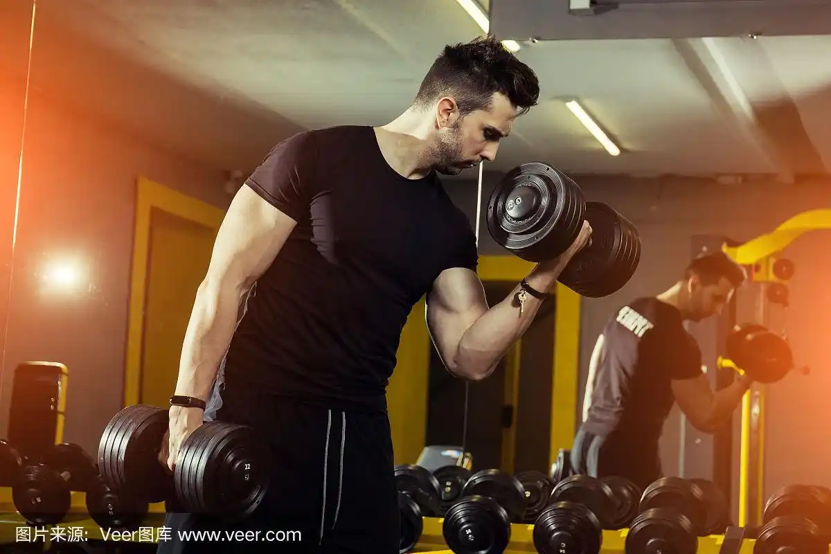 英俊的肌肉男在健身房努力锻炼