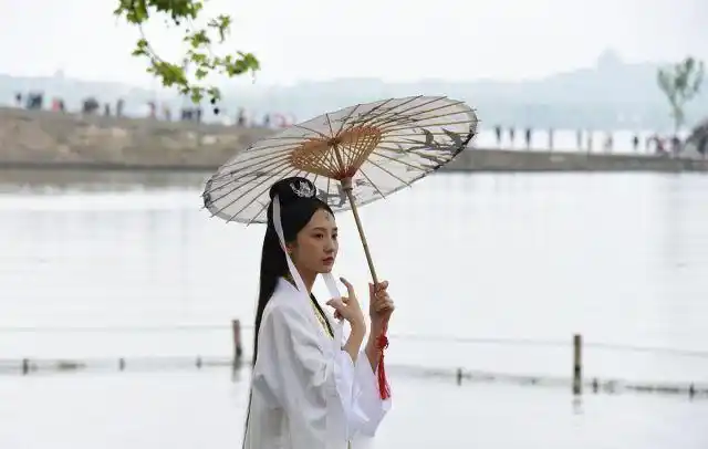 1 / 6 近日,在杭州西湖景区北山街和断桥,出现了许多打着绸伞的白娘子