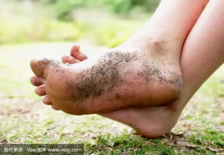 孩子的脏脚,交叉着脚踝,放松着