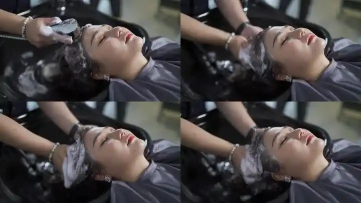 女性闭眼躺在美发沙龙洗头