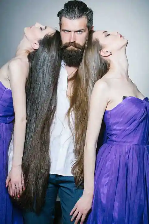 穿着白色衬衫的胡子帅气的男人和长头发的紫色女装的两个年轻漂亮的