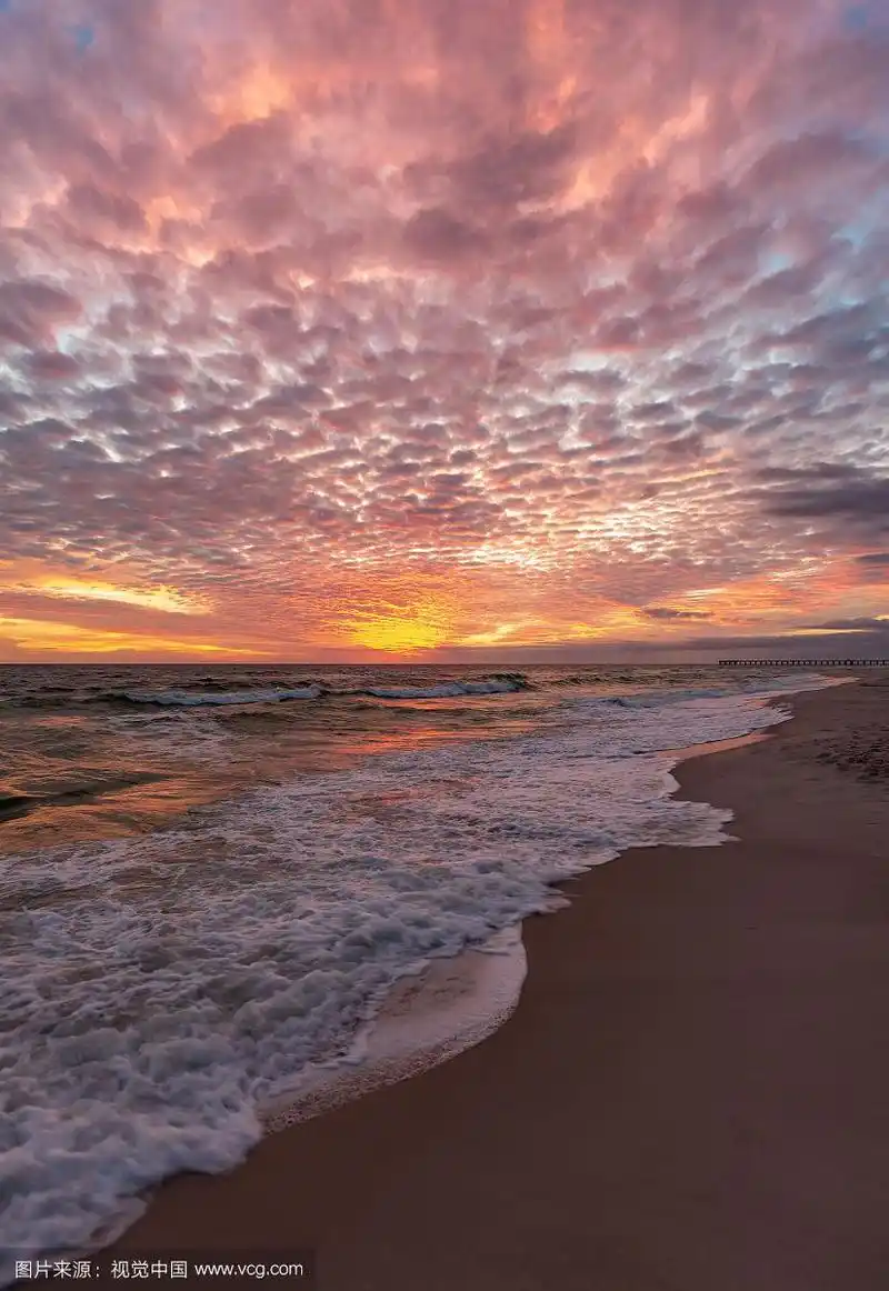 夕阳下阴沉的天空下的大海和海滩