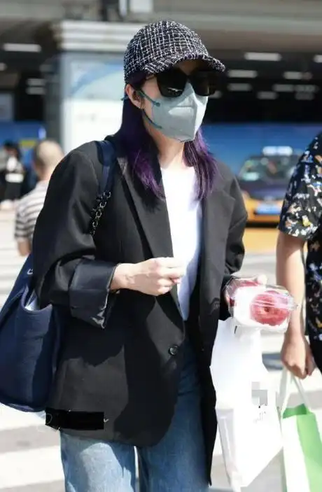 杨千嬅脚踩黑色皮鞋,头戴浅蓝色棒球帽,同时搭配了一款墨镜,把头发染