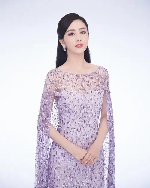 佟丽娅主持2020央视#春晚#的第二套造型,身着紫色星空披肩礼服配以