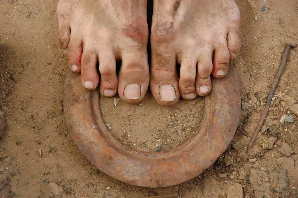 地面上的脏脚,肮脏的人光着脚站在地球上的特写镜头.