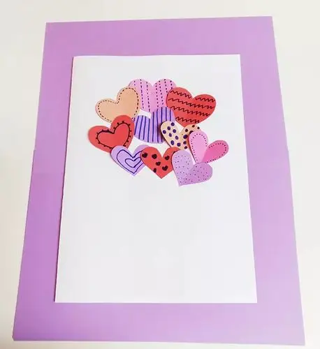 把装饰好的桃心按照自己喜欢的顺序,粘贴到白色a4纸上.