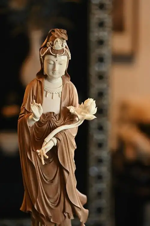 面容丰润,肩头披帛服帖,裙摆与垂带自然宛转,菩萨手持半开莲花,体态