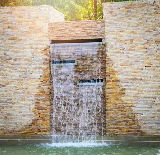 石砖瀑布墙和水池美丽的设计装饰在花园里