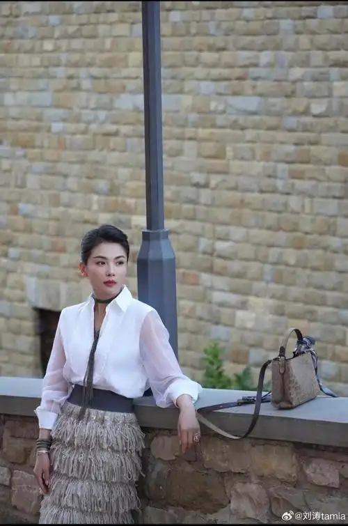 在这组照片中,刘涛身穿白色衬衫搭配半身长裙,展现出了她知性优雅的一