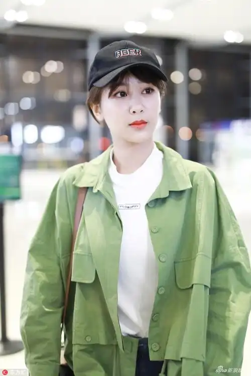 杨紫现身机场大步流星 绿衣白衫清新红唇衬雪肤