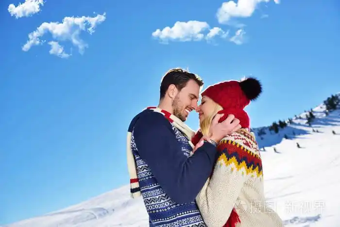 在冬季公园拥抱的恩爱夫妻.他们把彩色软帽和围巾