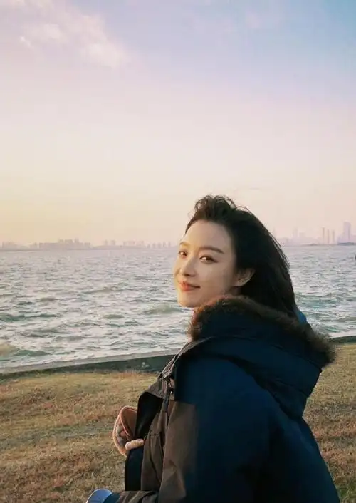 照片中,倪妮面朝大海,吹海风看落日氛围感十足,回眸一笑令人心动.