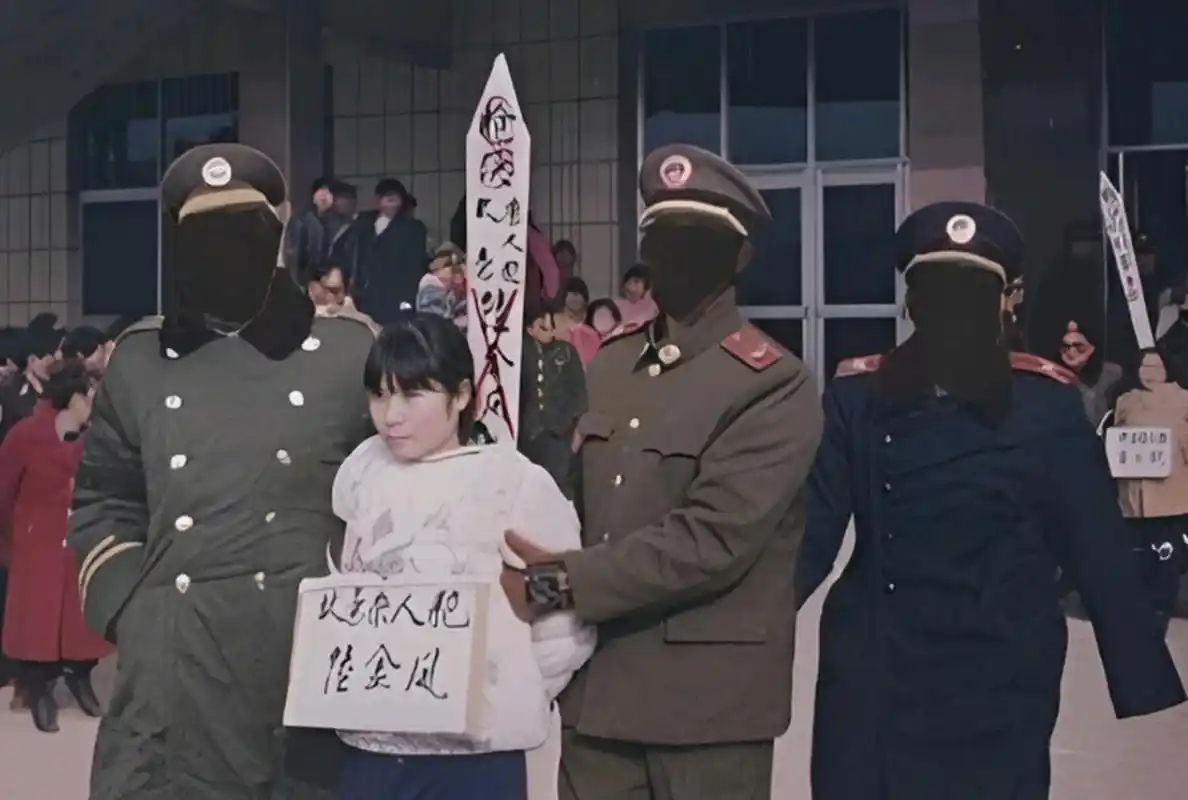 她是一个让人心疼的女死刑犯,在画面中,她正配合法警捆绑绳索.