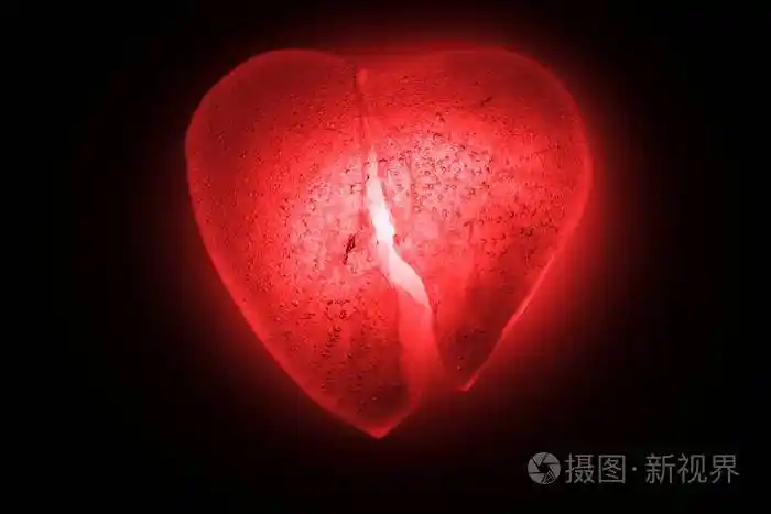 冰冻成半心形象征着一个明亮的红色特写镜头在黑暗中发光.