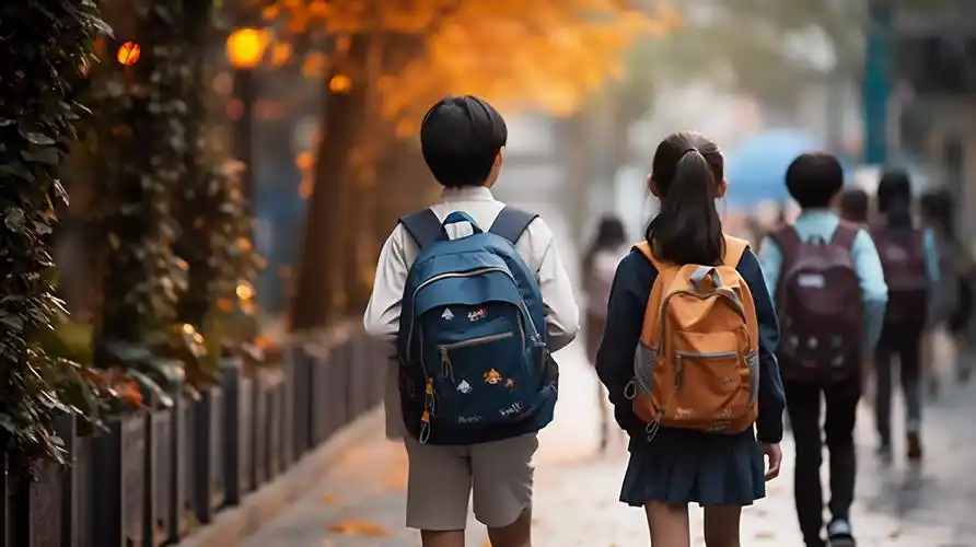 背着书包上学的小学生孩子背影学校校园开学季教育学生学习成长