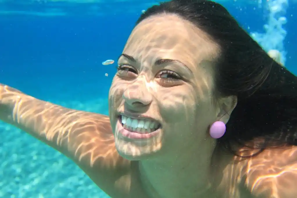 水下游泳的女人,水下游泳在海微笑的女人.在度假胜地的年轻女子游泳.