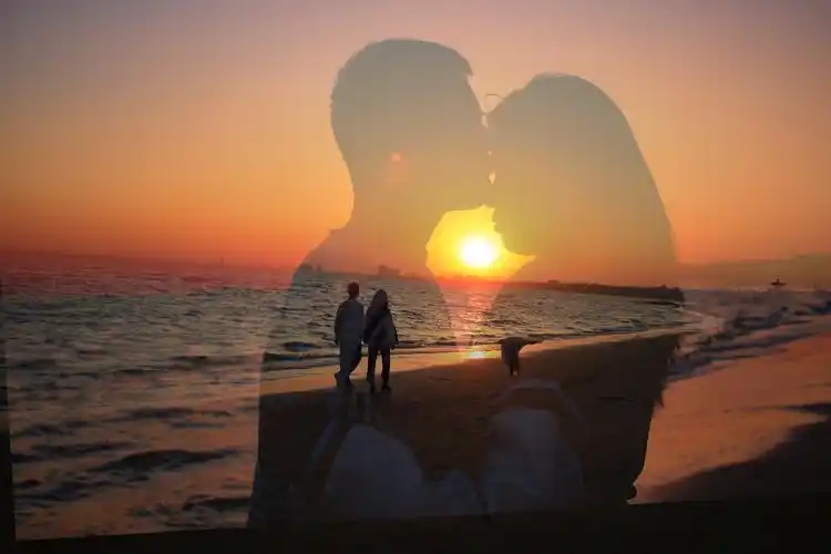 夕阳西下在海边漫步的情侣