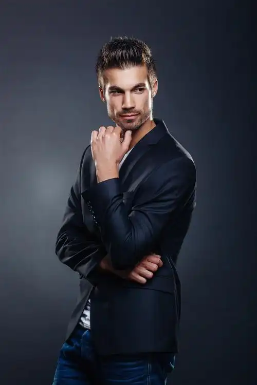 穿着黑色西装外套在摄影棚摆拍的帅哥高清图片