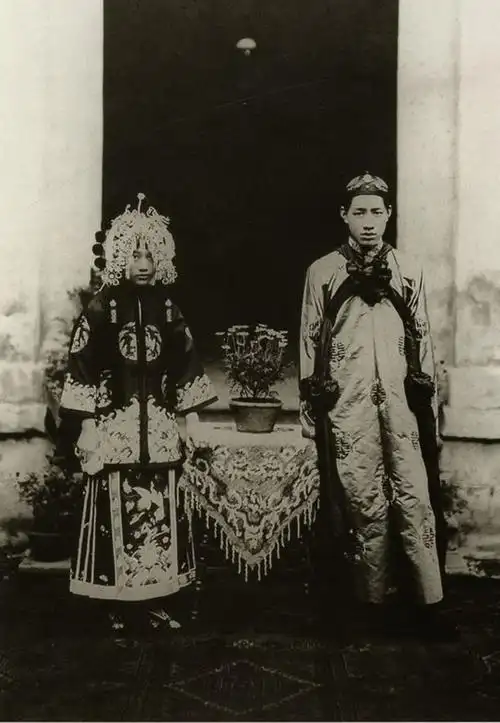 民国初年结婚礼服:新娘头戴凤冠,身着大红绣裙,脚穿配套红绣鞋;新郎身