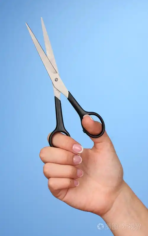 女性手用颜色背景上的剪刀