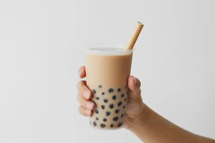 灰底手拿奶茶喝奶茶一杯奶茶珍珠奶茶