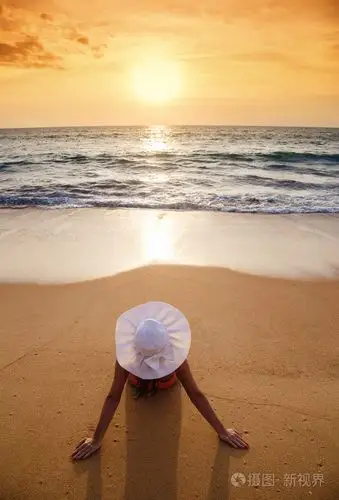 那个年轻的女人在比基尼在沙滩上的一顶帽子照片-正版商用图片1iz1ba