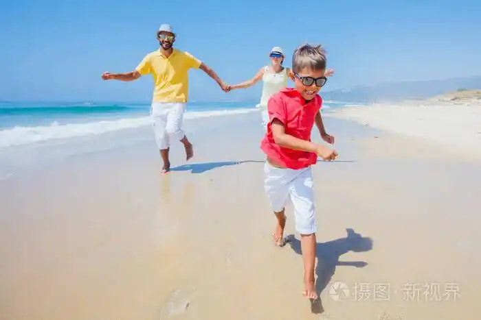 家庭在沙滩上玩耍和奔跑