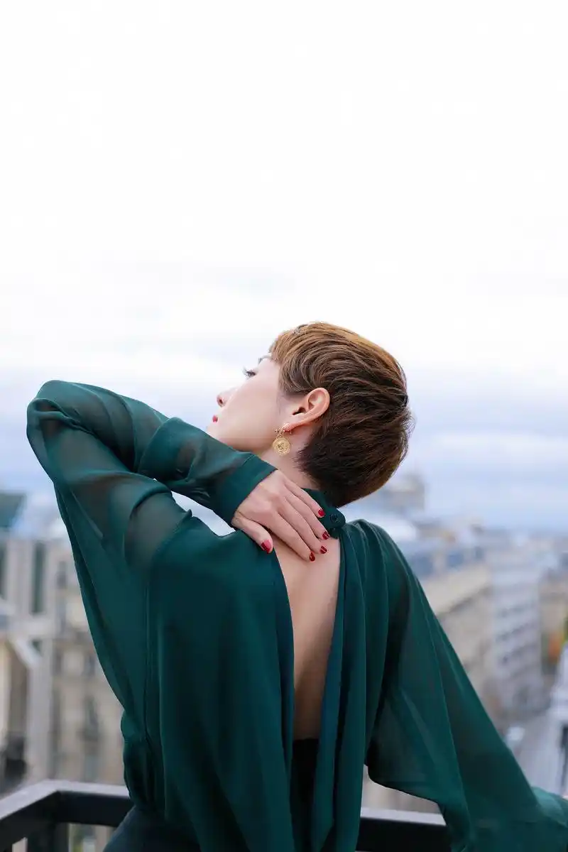 马伊琍身着松绿色真丝露背装,搭配羊毛迷笛裙及黑色长靴出席akris春夏