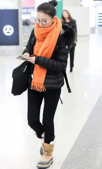 甄嬛传宁嫔扮演者热依扎现身北京机场,橘黄色围巾显得活力十足!