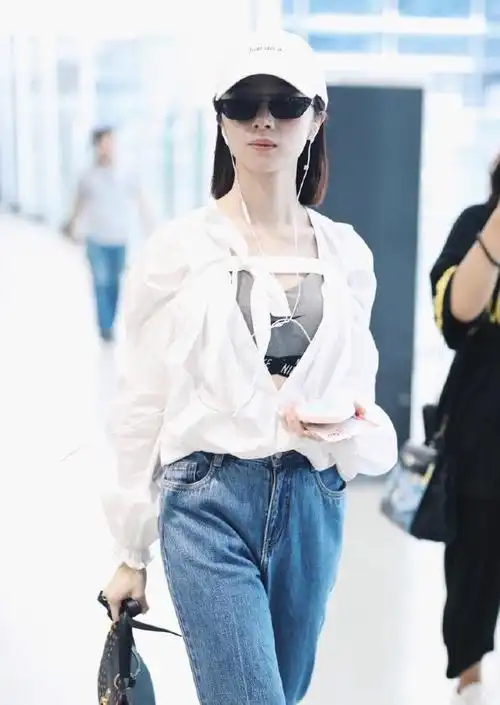 胡冰卿戴棒球帽和墨镜穿白色衬衣搭配蓝色牛仔裤现身机场皮肤白皙